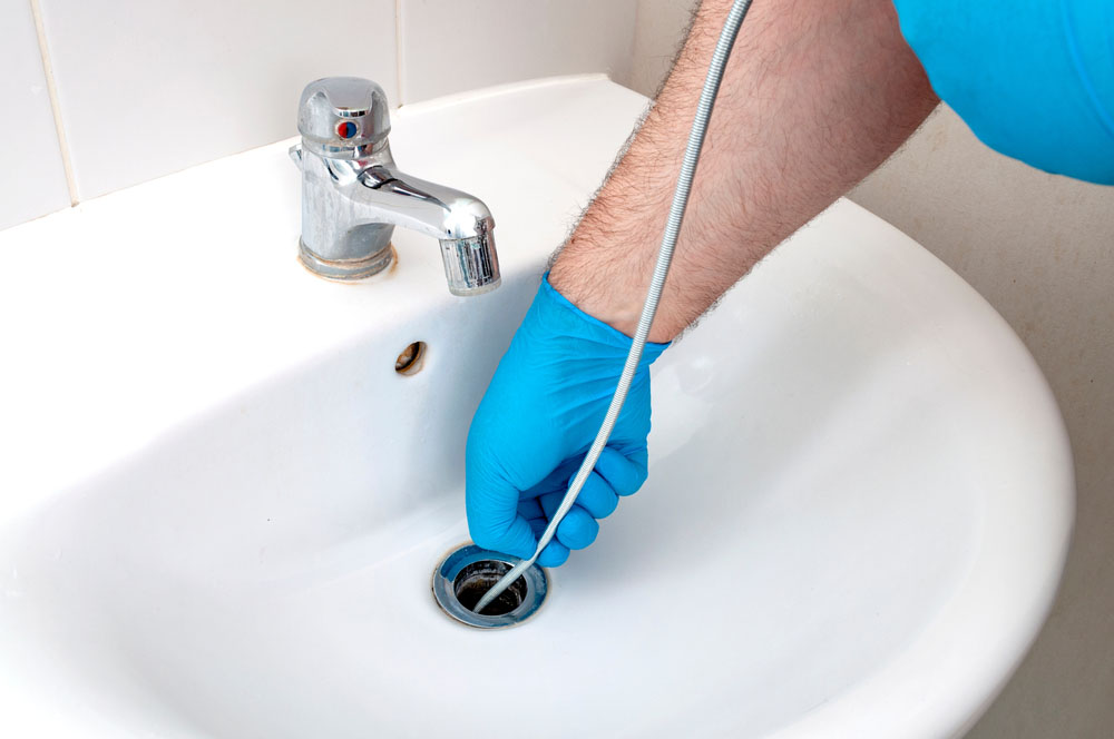 person drain snaking a sink